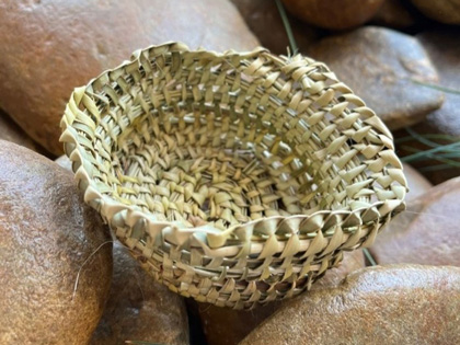 A cane basket sitting on rocks.