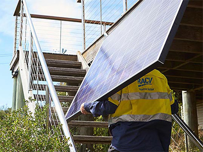 RACV tradesperson holding a solar panel.