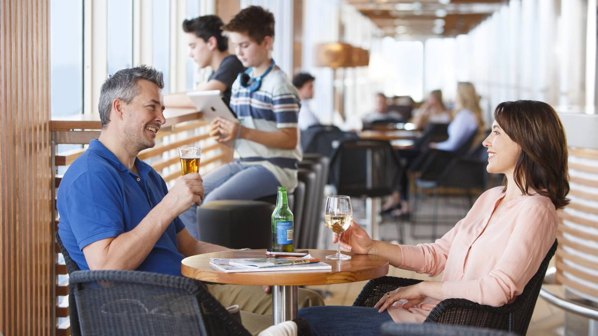 A couple and their two sons enjoying a drink during a day sailing on Spirit of Tasmania