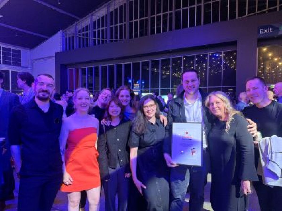 Many people dressed up holding a framed award