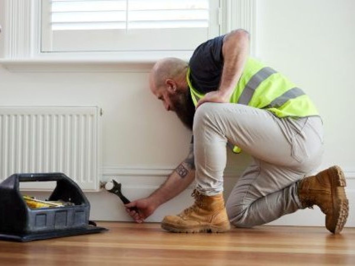 RACV tradesperson fixing a gas heater with a spanner