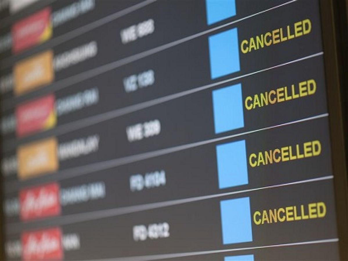 A screen at an airport showing cancelled flights