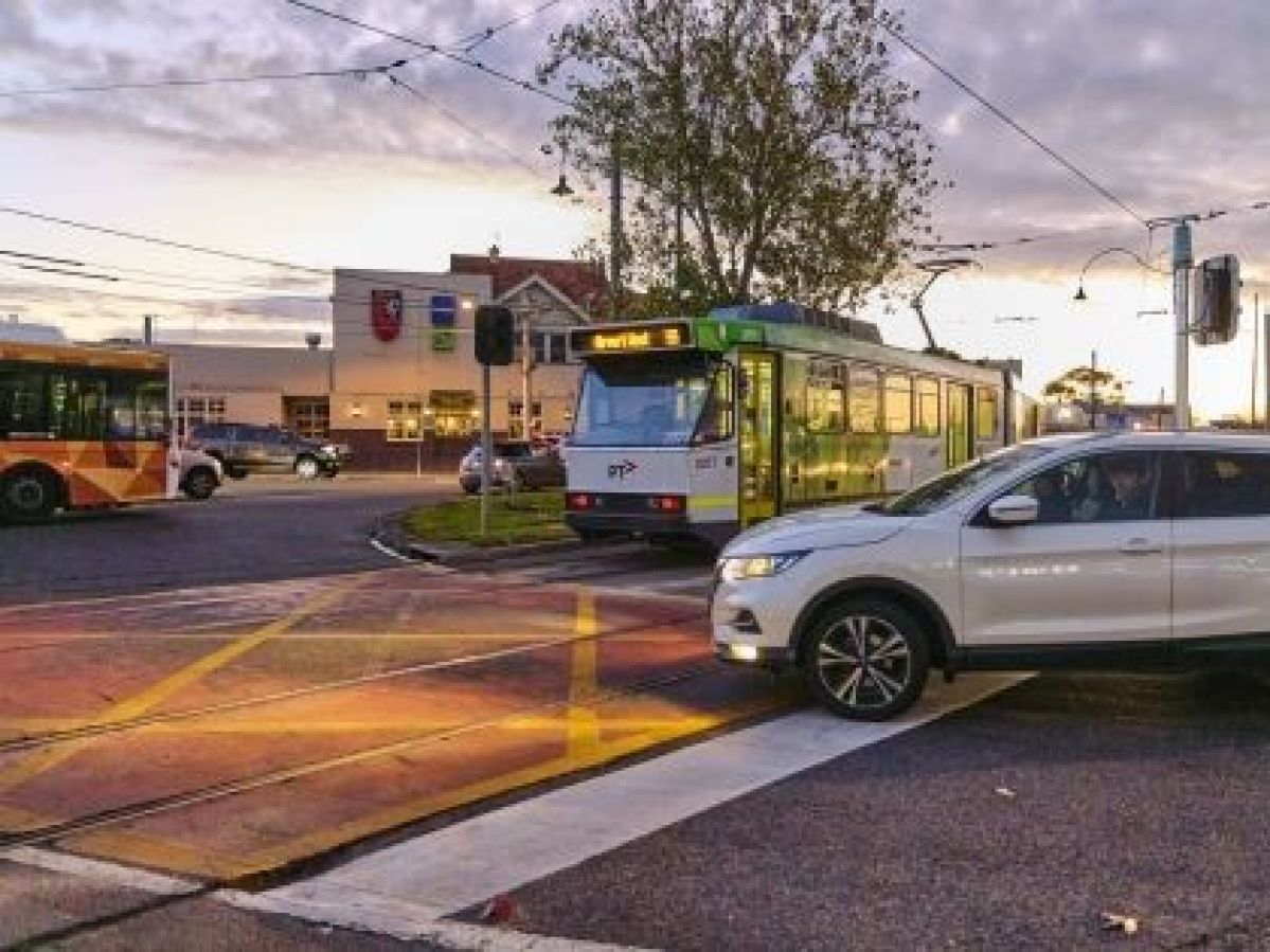 Car, bus and tram all meeting at Essendon intersection