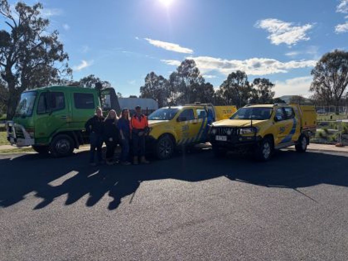 A family of four in front of a tow truck and two RACV patrol cars