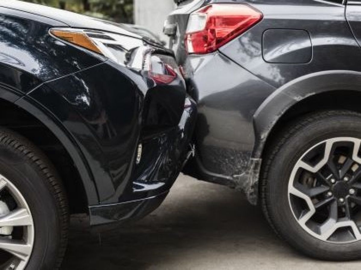 A black car has a minor collision with a grey car