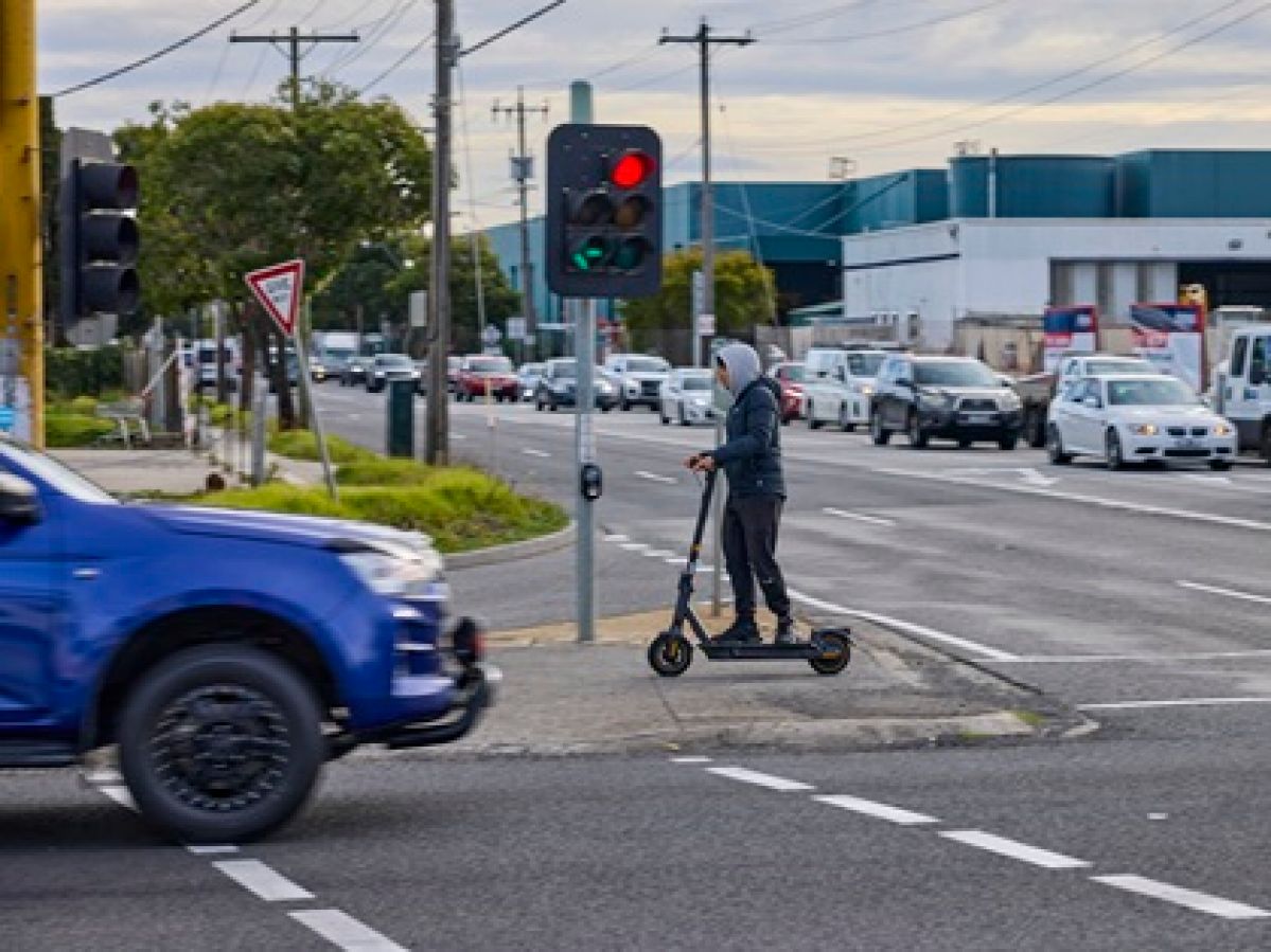 Man on escooter without a helmet.