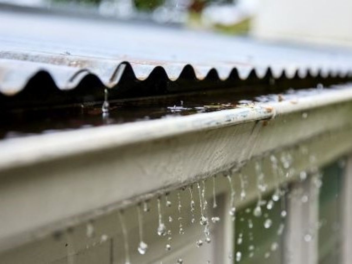 Rain spilling over a roof gutter