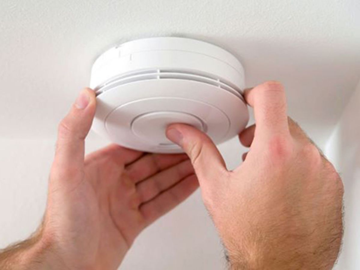 Person checks smoke alarm