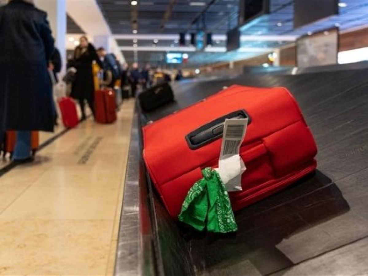 A red suitcase on an airport conveyor belt