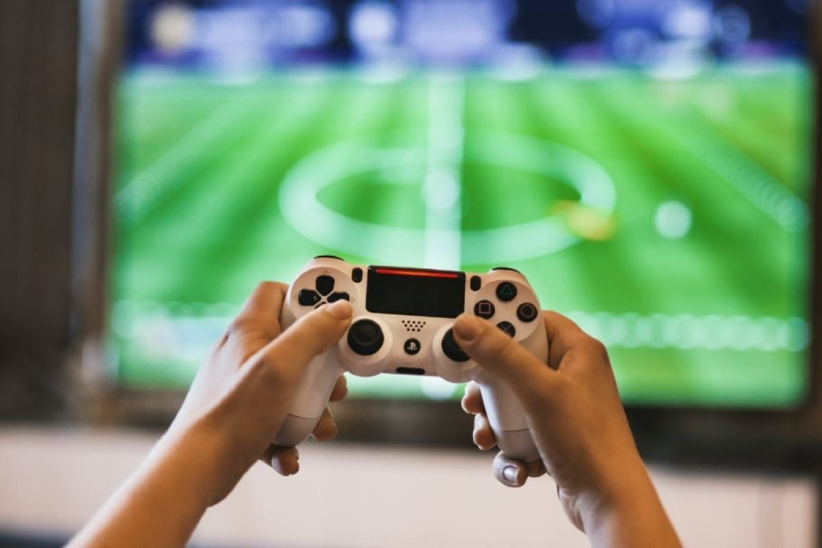 man playing a video game with a PlayStation controller