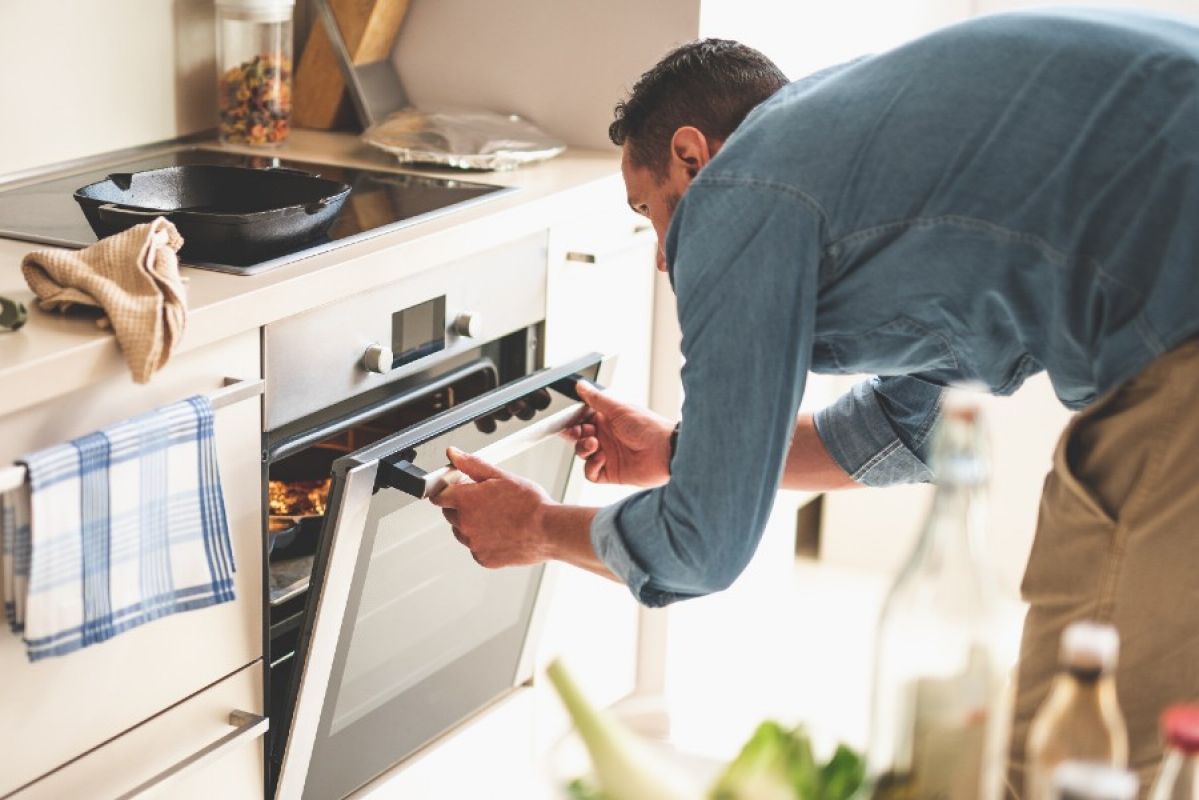 man cooking with an electric stovetop and oven