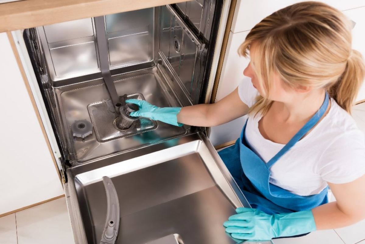 woman unclogging a dishwasher