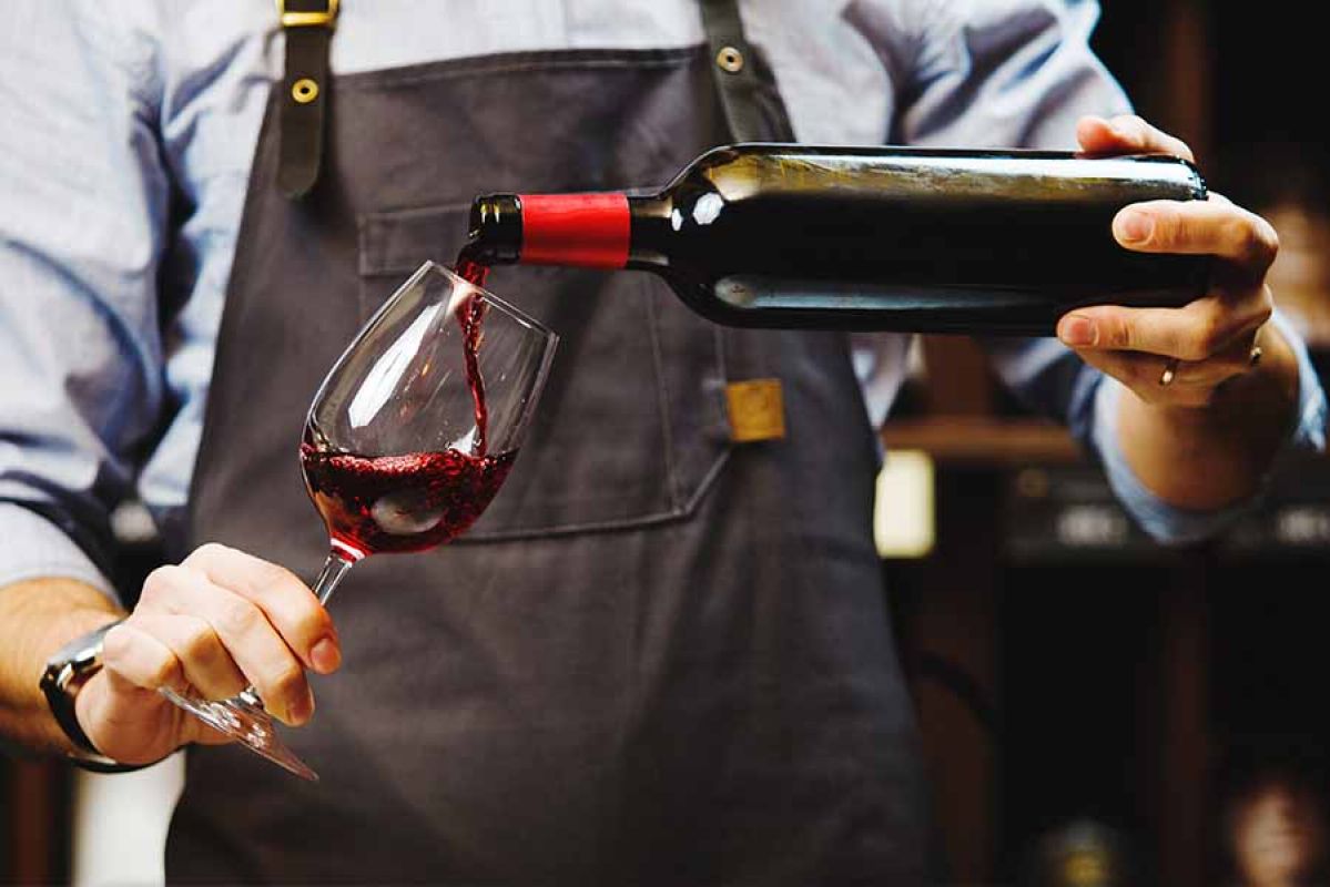 Close up of man pouring glass of wine