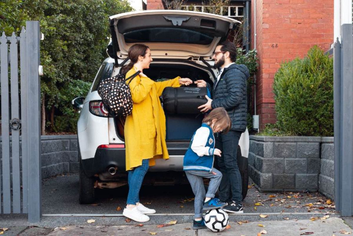 family unpacking car in driveway