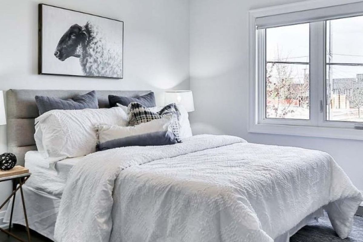 bedroom with white furnishings and artwork of sheep