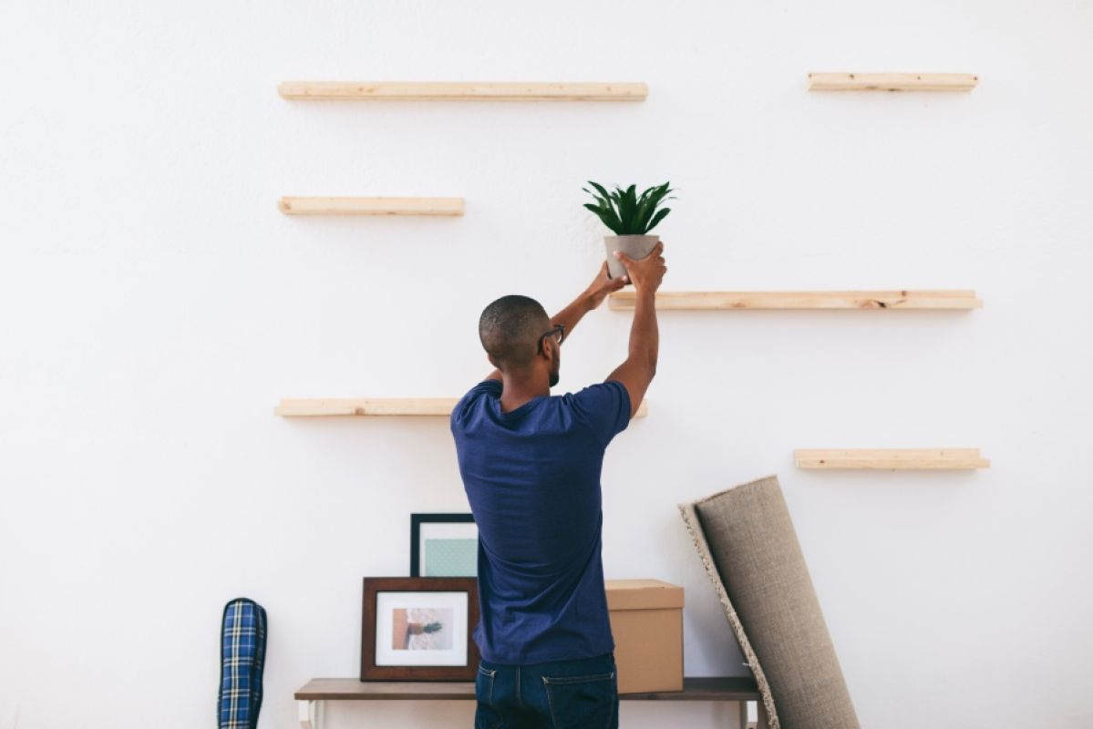man installing floating shelves