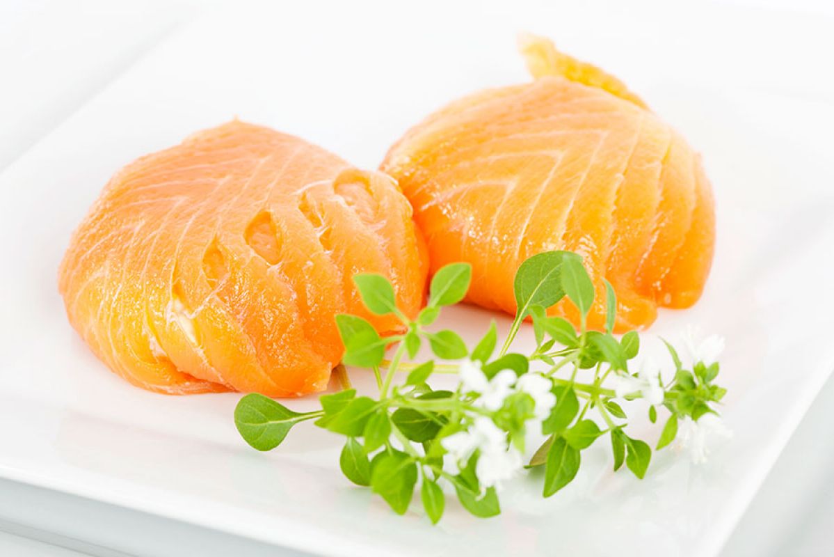Fresh salmon presented on a white plate with garnish