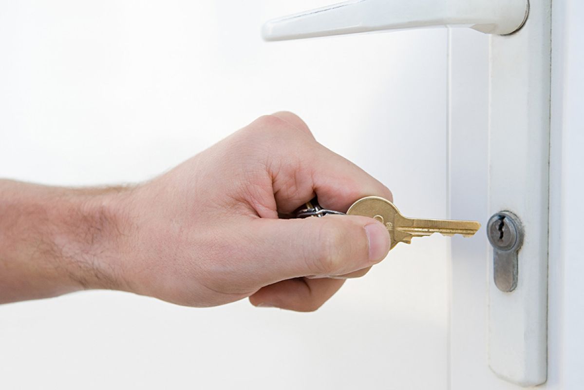 Person inserting keys into front door lock