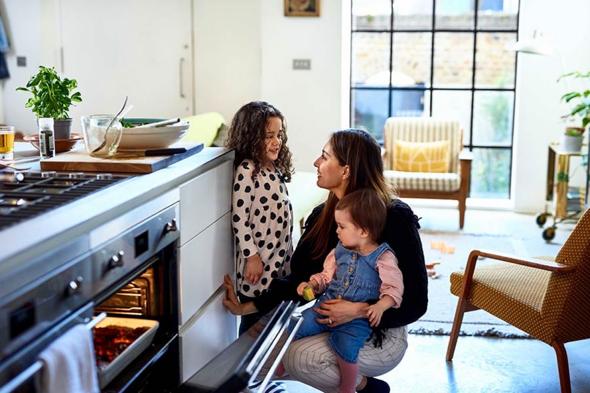 Mother and two kids opening oven