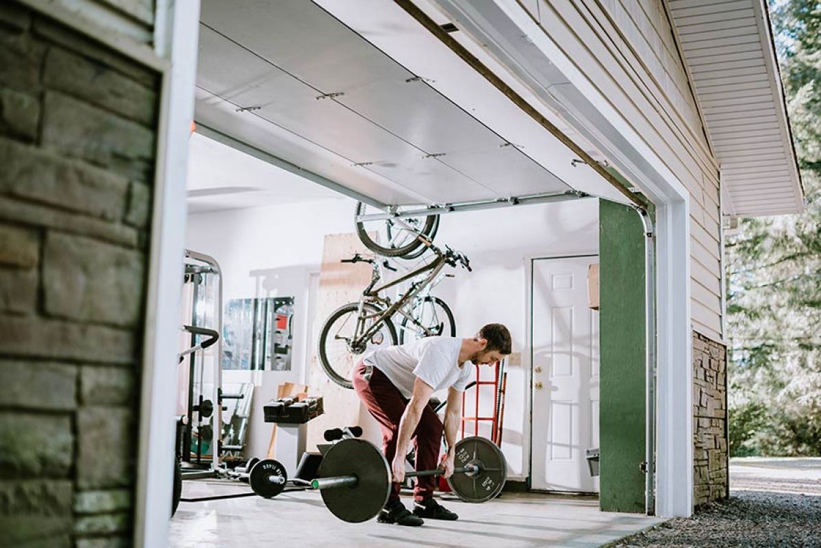 A person lifting weights in the garage