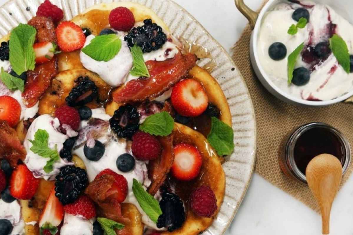 pancakes on a plate with berries and bacon