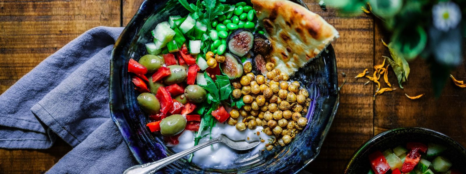 vegan bowl of vegetables on hand towel and wooden table