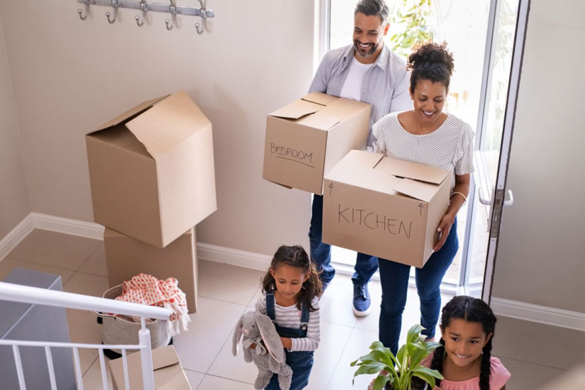 A family  moving boxes into a new home