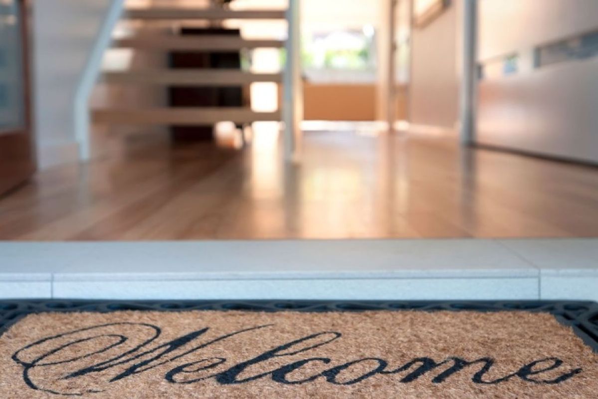welcome mat at front of house near wooden florboards