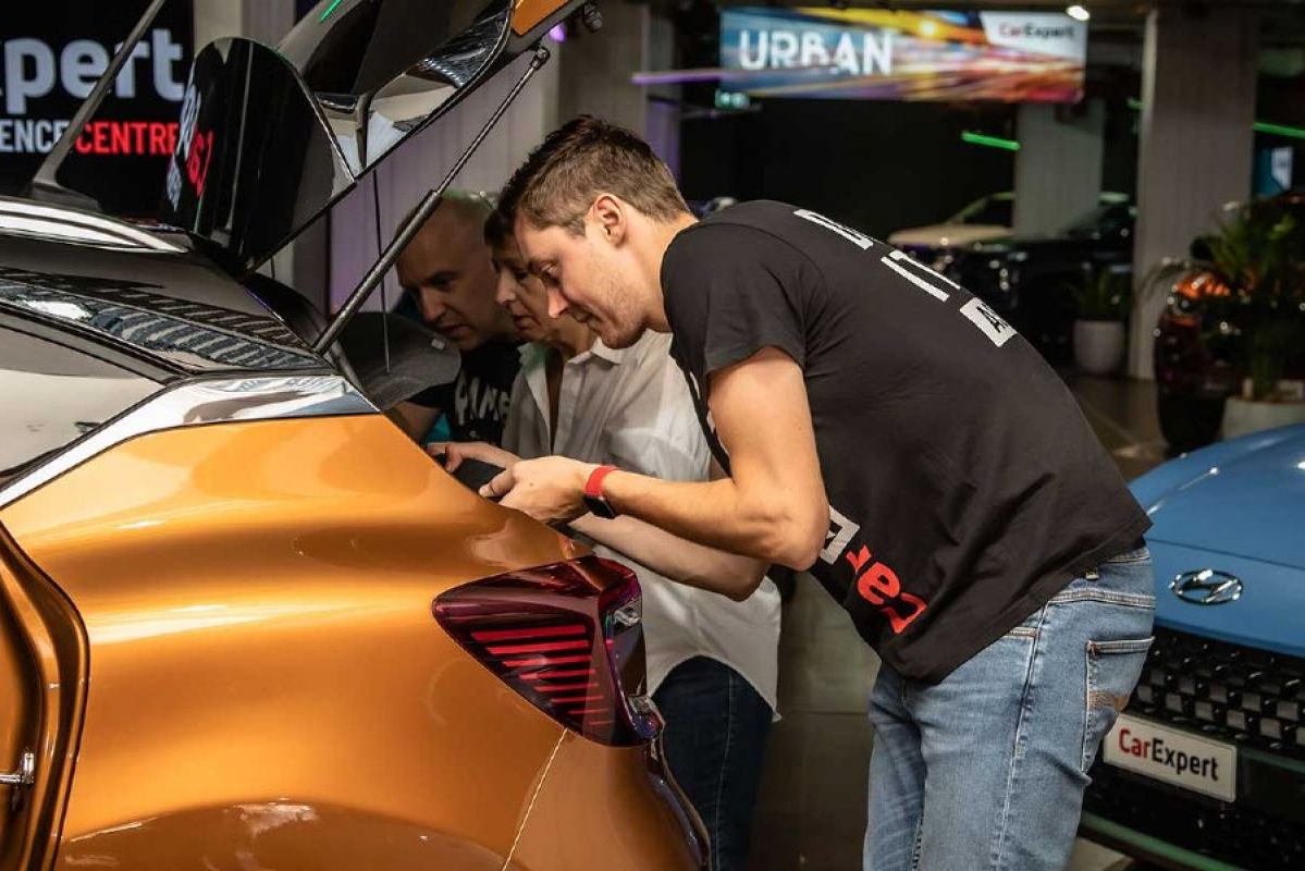 People checking boot of car