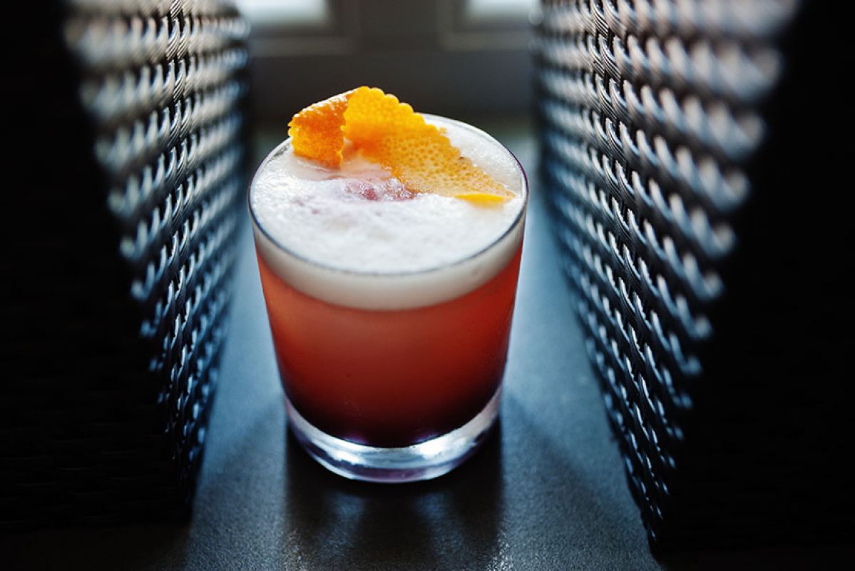 Refreshing Southside Fizz cocktail with orange garnish