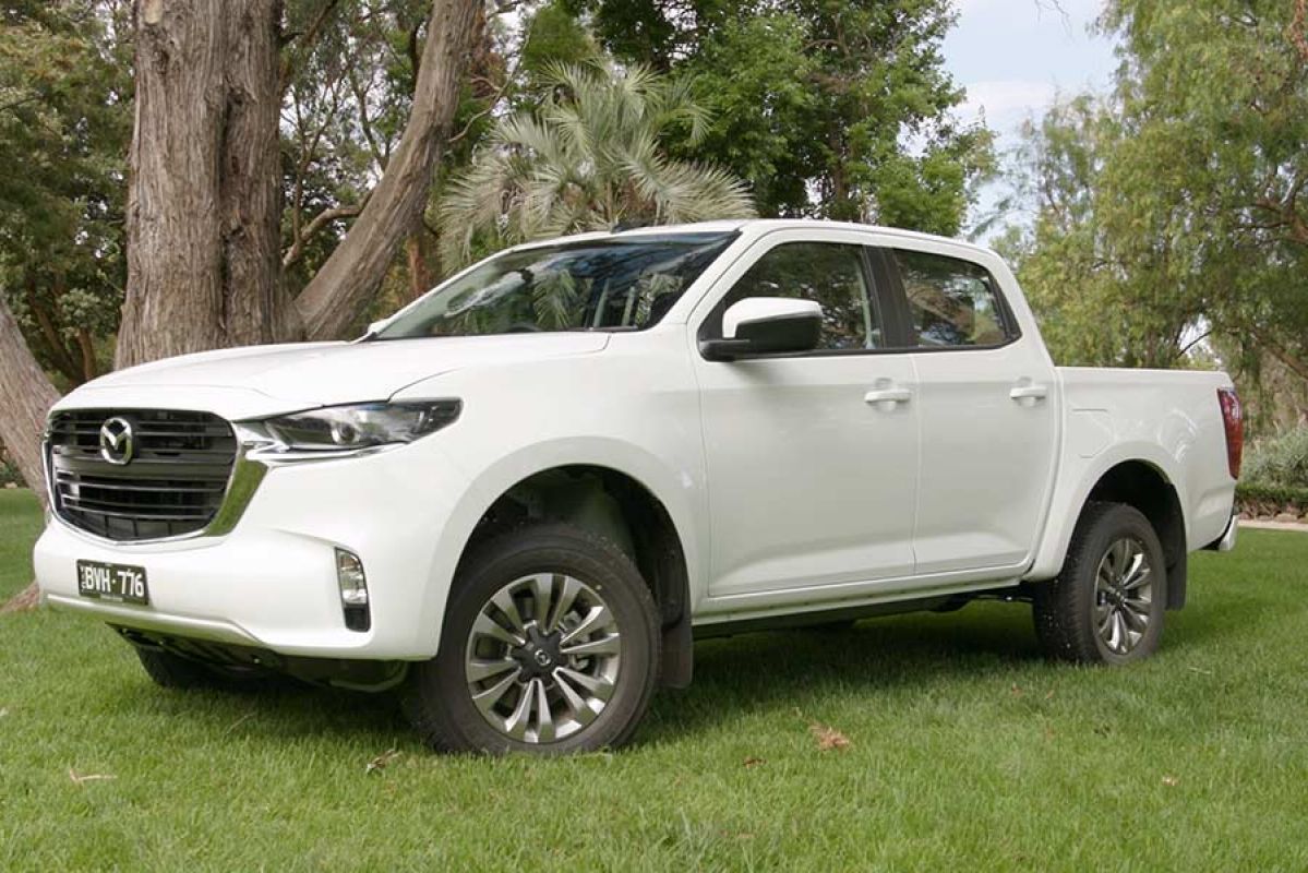 A white Mazda BT-50 XS parked on a lawn.