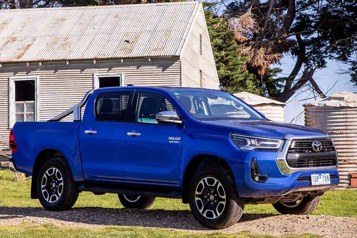 toyota hilux blue parked in front of farm