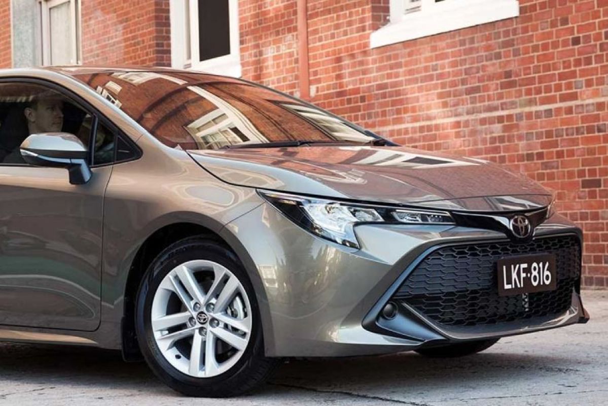 toyota corolla ascent sport parked in front of building brick wall