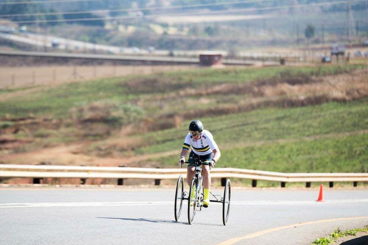 Carol Cooke AM cycling up a steep road at the World Championships in 2019