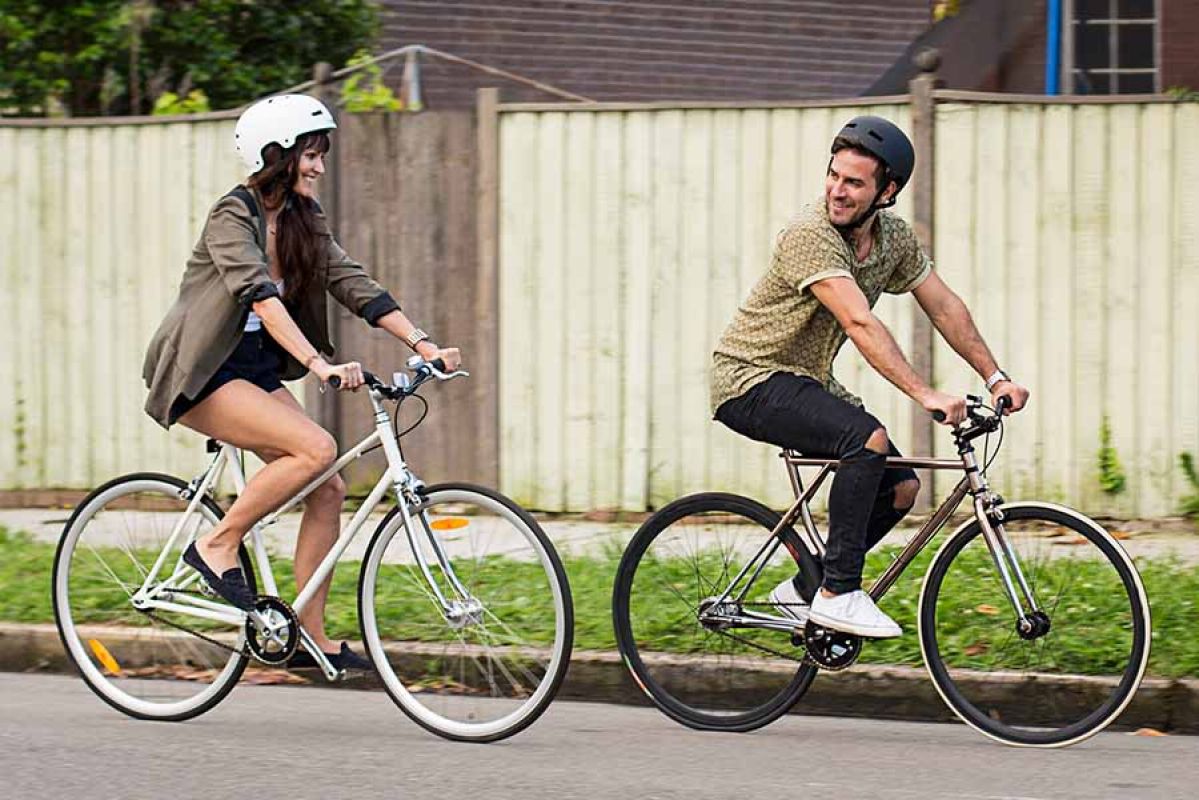 Man and woman riding bicycles on suburban street