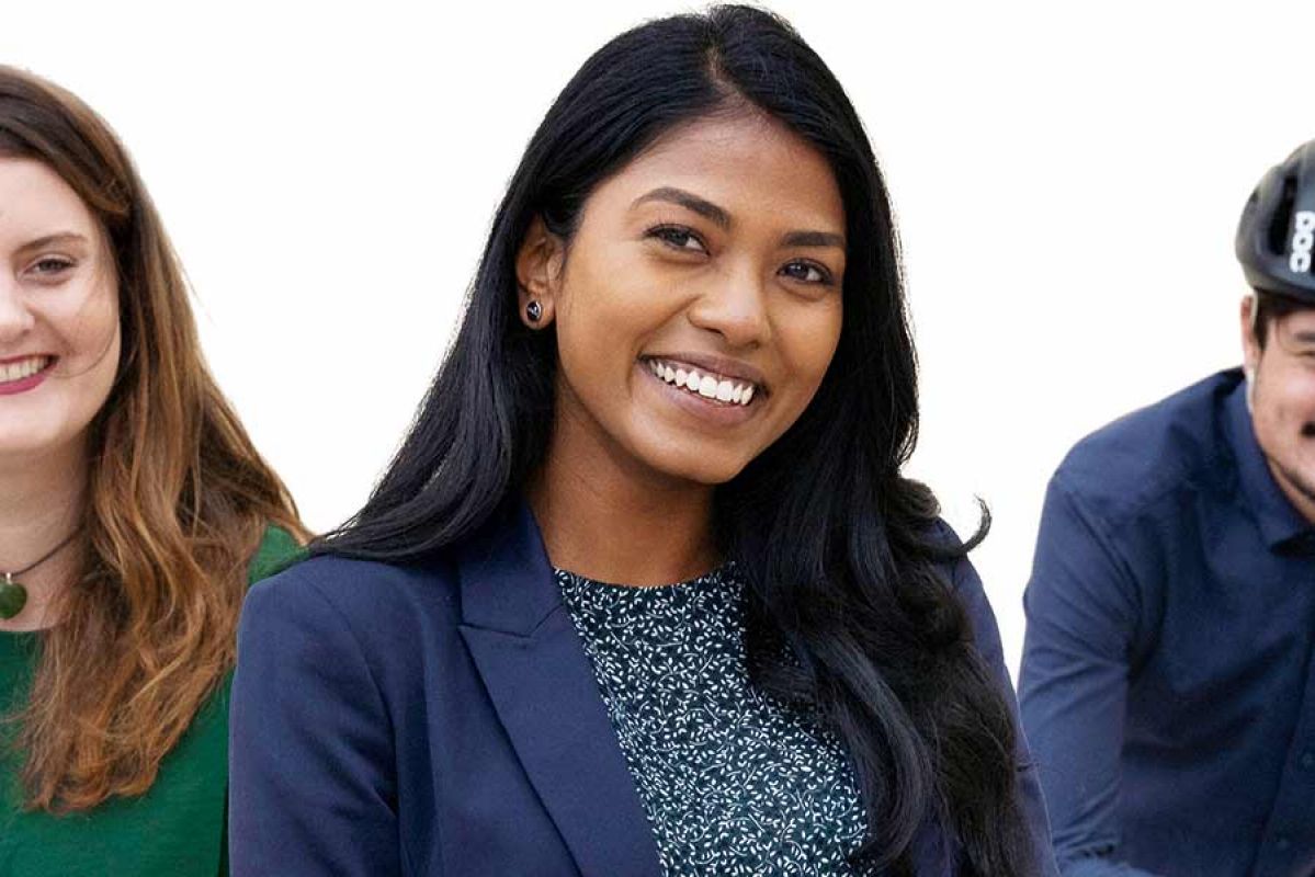 Three people smiling with white background.
