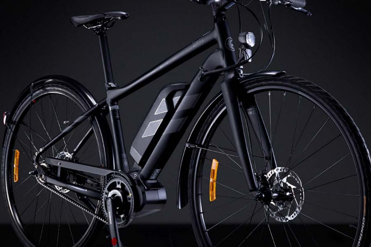 Black ebike standing up against black background.
