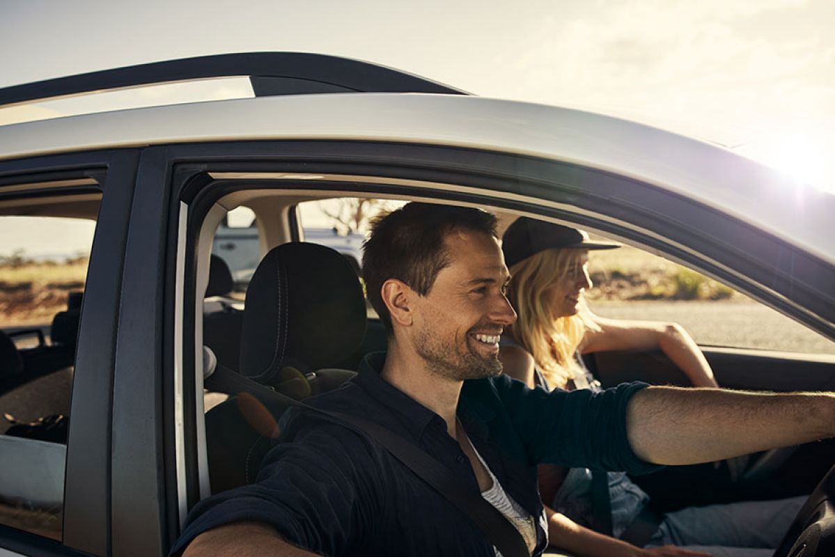man and woman driving in car