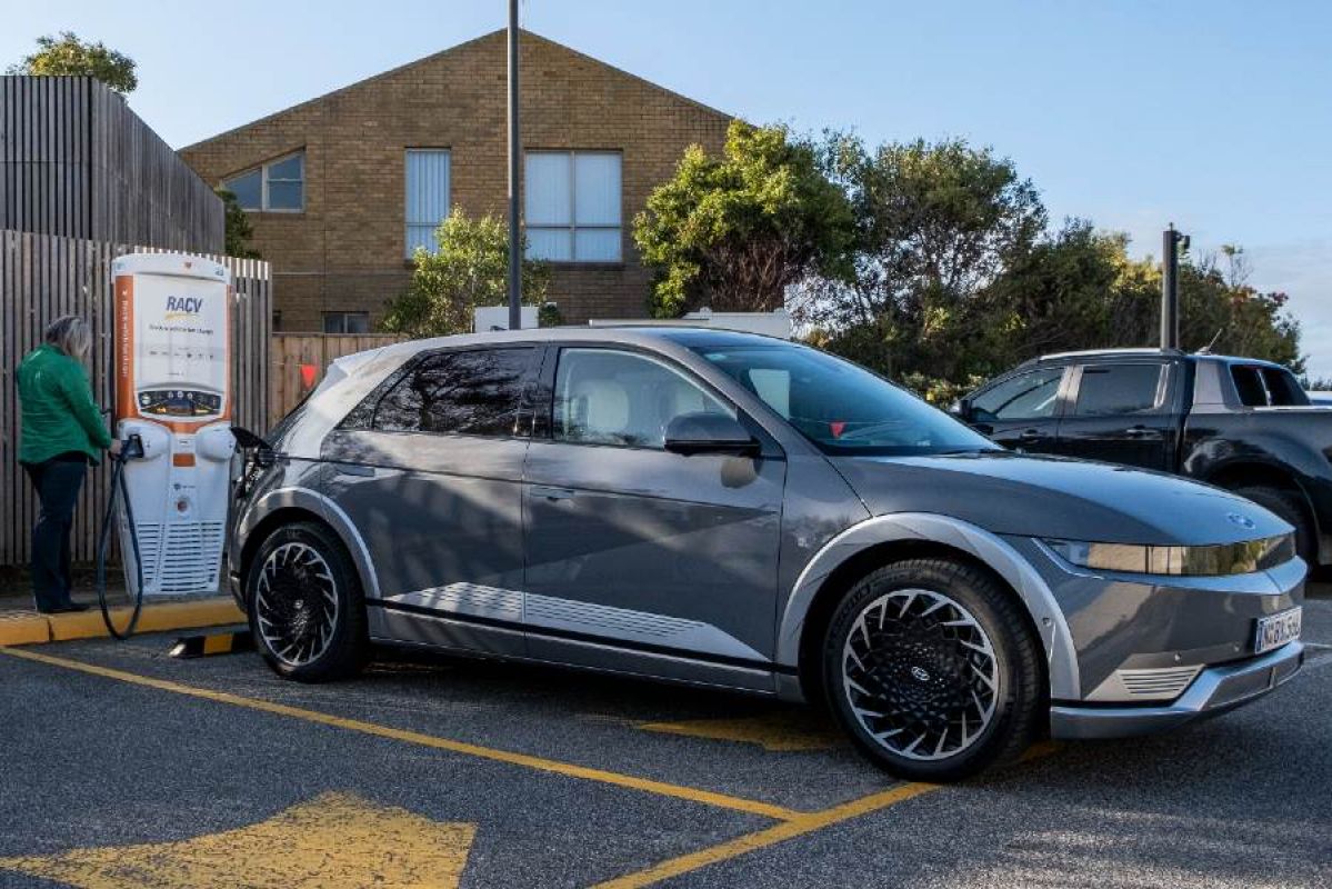 Woman plugging an EV charger into her car