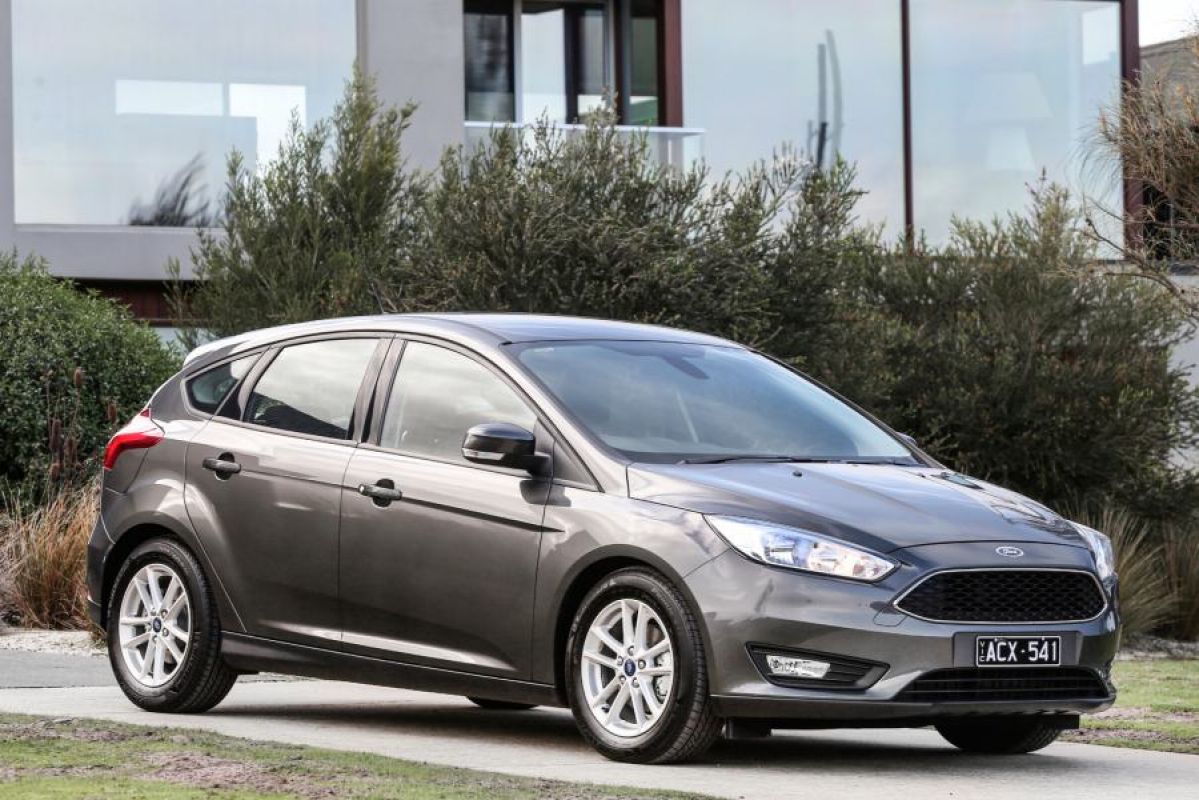 gray ford focus st parked in driveway next to shrubs