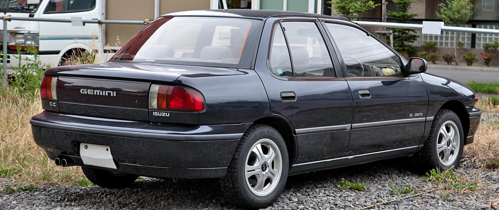 black holden gemini diesel parked on gravel near fence and weeds