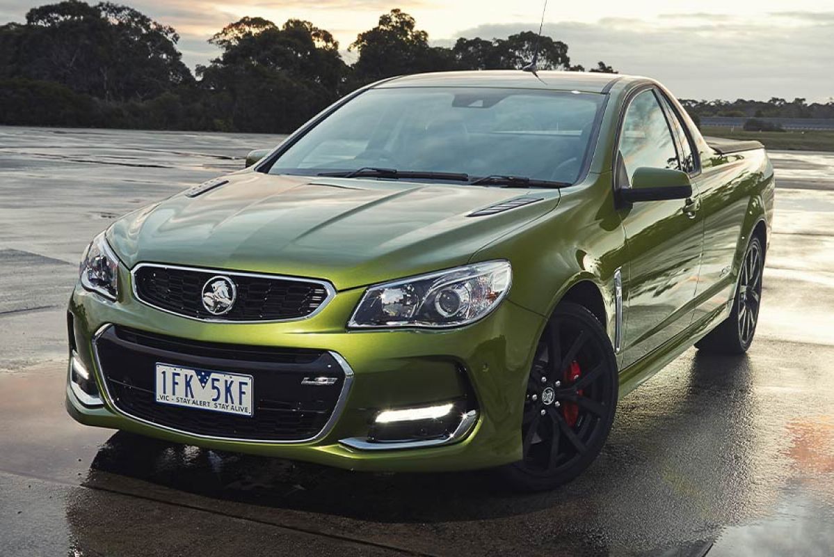 Front side view of a green Holden Commodore SS ute parked on a wet tarmac surface