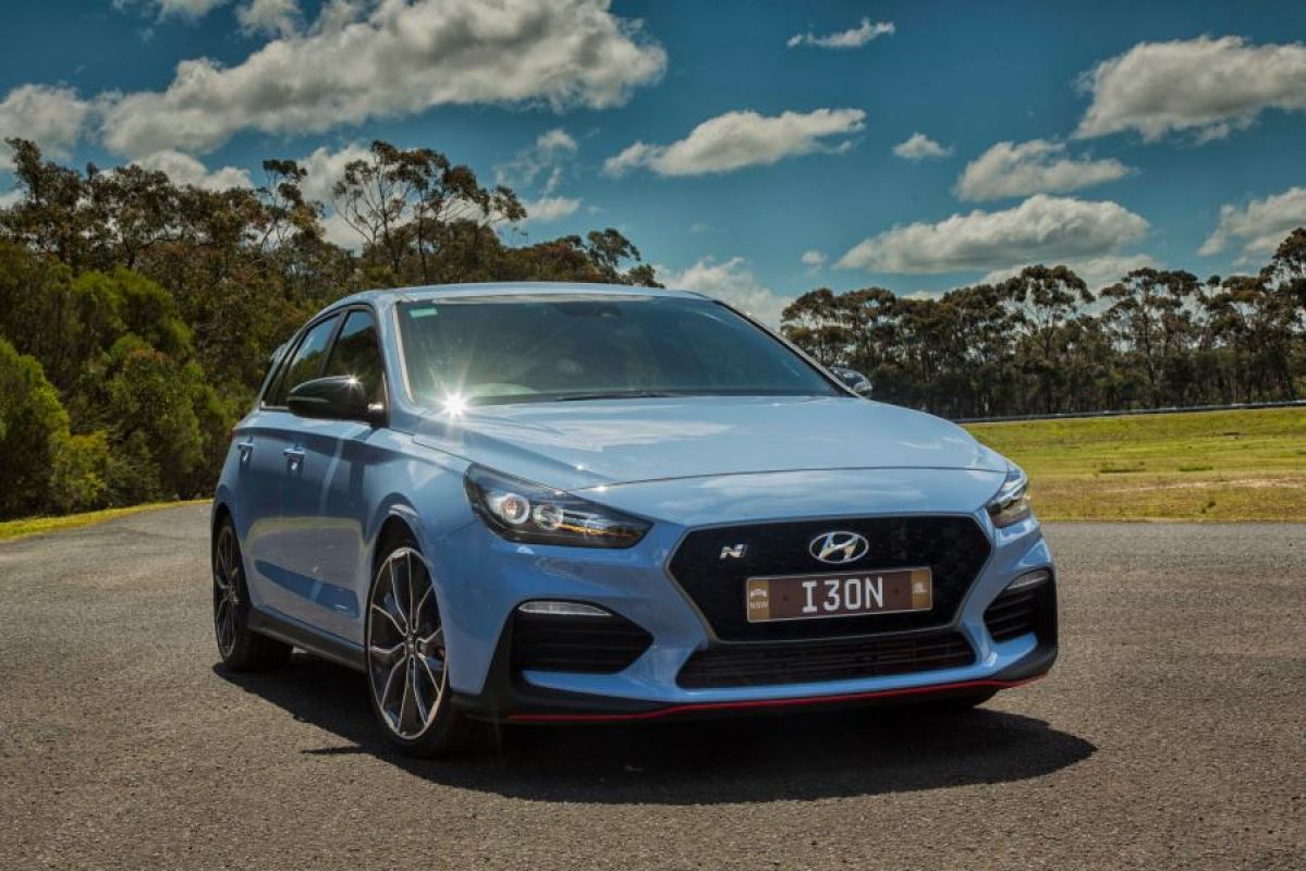 blue 2019 hyundai i30 performance parked on road next to grass