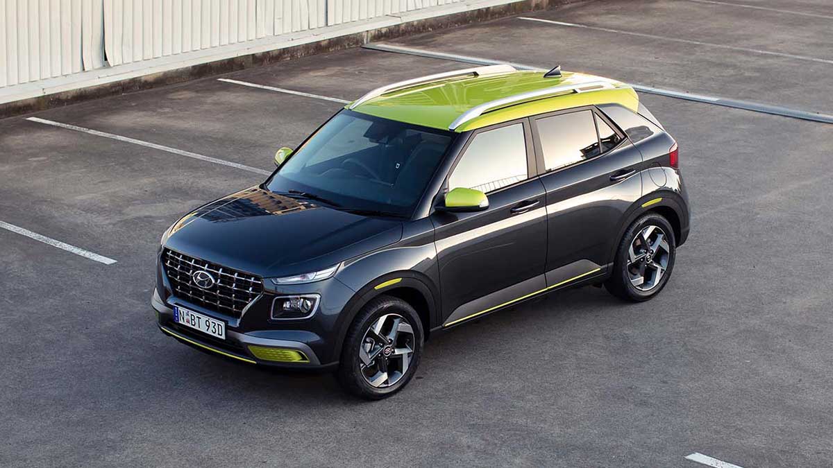 Top down shot of a gunmetal grey, with neon detail, Hyundai Venue SUV in a carpark