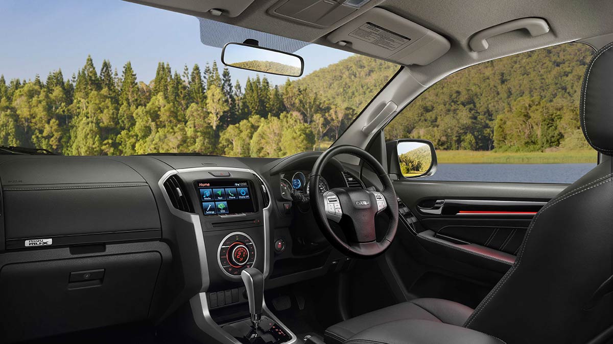 Dark grey interior of the Isuzu MU-X 2019 showing the driver's seat, steering wheel and centre console