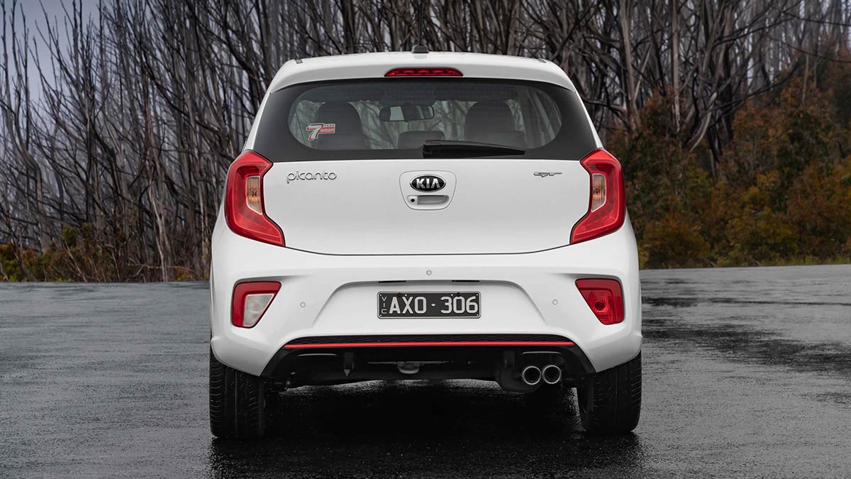 Rear view of a white Kia Picanto GT 2019 car parked on a wet tarmac surface