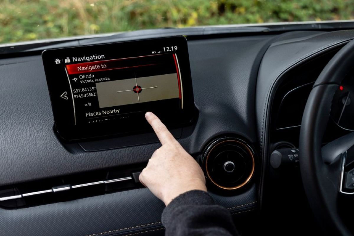 person using navigation interface on infotainment screen in Mazda CX-3 Touring SP