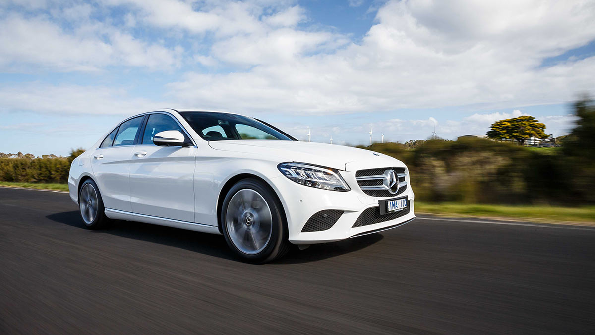 Front side view of a white Mercedes-Benz C 200 in motion