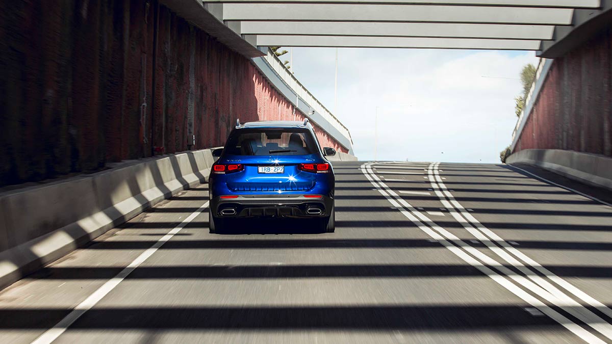 Rear view of a blue Mercedes-Benz GLB250 2020 car driving down a freeway