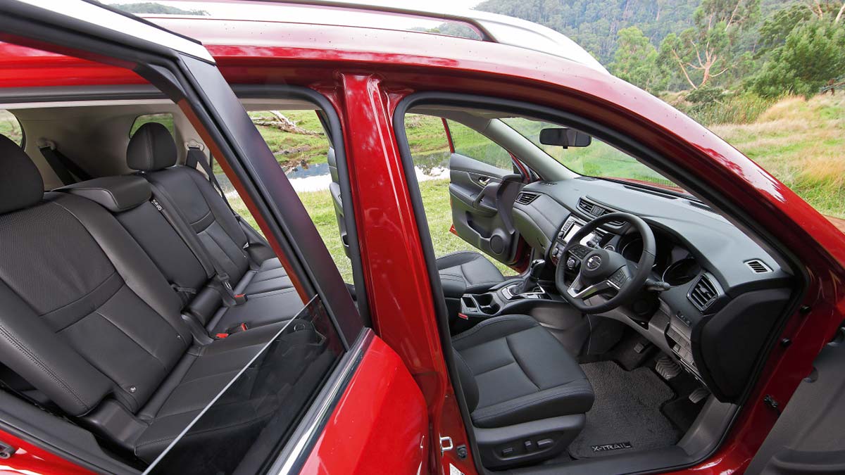 A red Nissan X-Trail 2017 with its doors open showing the grey interior of the car